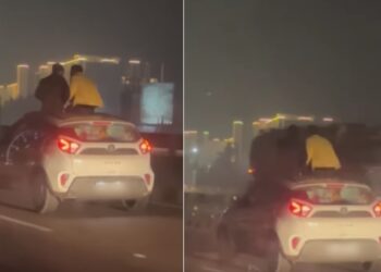 Two Men Sitting on Sunroof of Tata Nexon